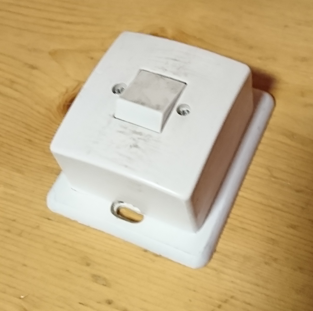 Photo of old lightswitch, showing a spacer plate beneath it.
